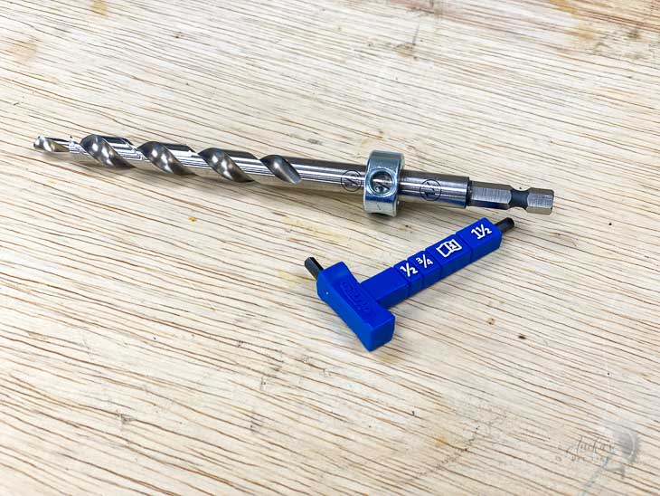 drill bit with drill collar and wrench on a workbench