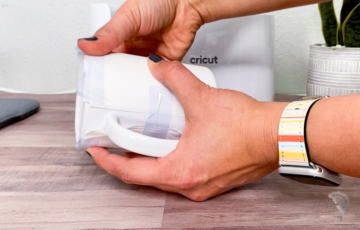 Woman applying butcher paper to the Mug to use in the Cricut MugPress