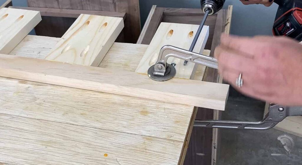 Woman building the brace for the floating shelves using pocket holes