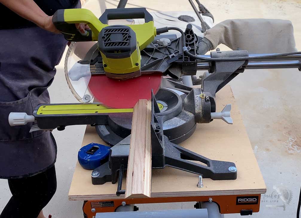 Woman cutting the floating shelves on a miter saw