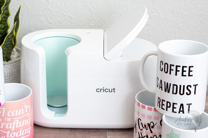 Cricut MugPress on table with mugs around it.