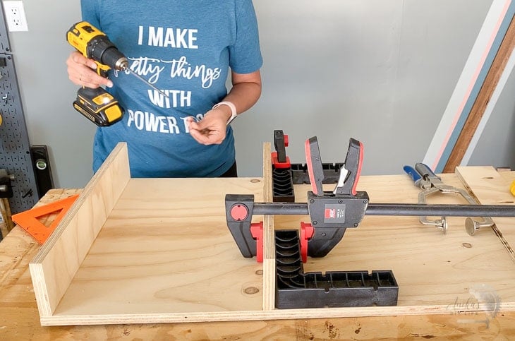 Woman building with right angles clamped to workpiece