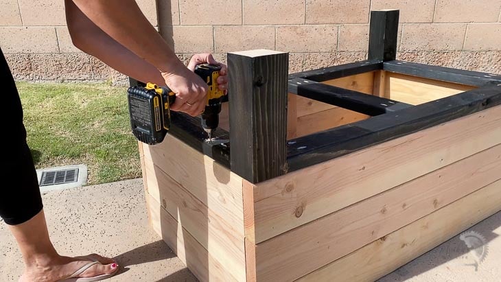 woman attaching the legs to the self-watering planter box