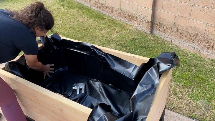 woman attaching the pond liner to the planter
