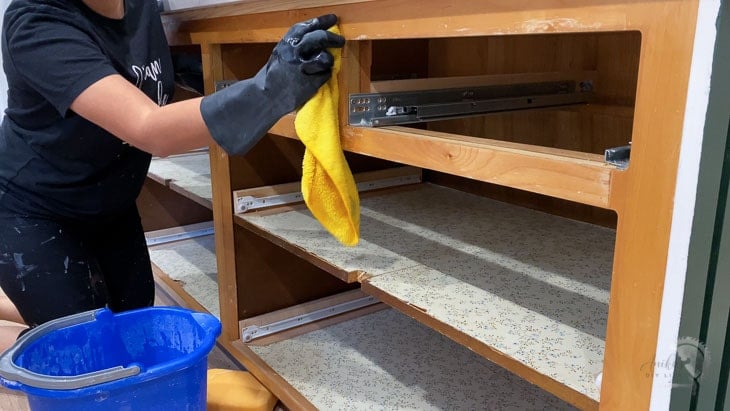 Woman cleaning cabinet with TSP to prepare for painting cabinets