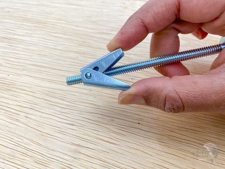Pinching butterfly toggle to insert into drywall