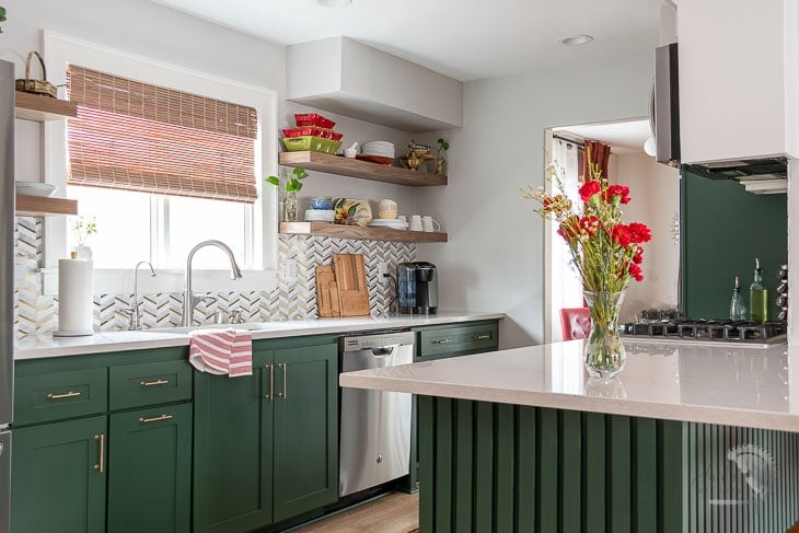 Kitchen with green cabinets and open floating shelves