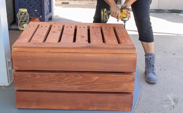 woman attaching the bottom of the DIY storage box