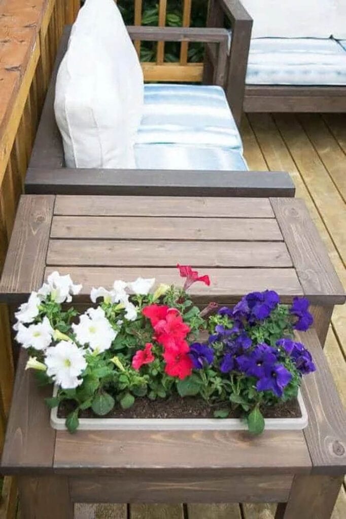 flowers in a DIY wood planter built into an outdoor end table