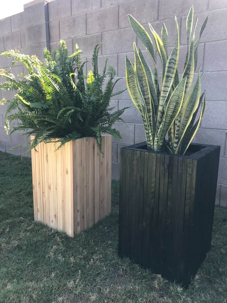 two tall wood planters made from scrap wood one stained black one natural