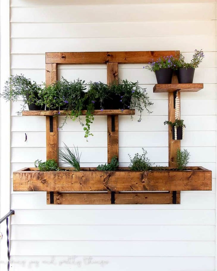 vertical wooden planter box system hanging on the outside of the house