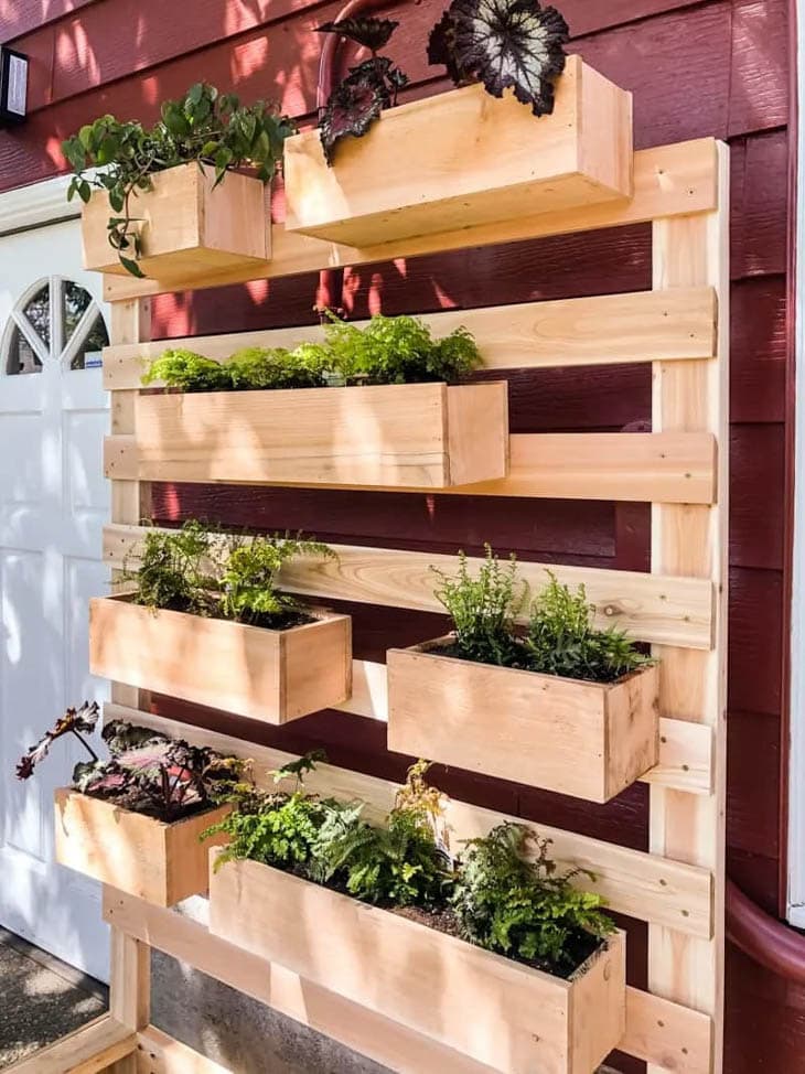 Slatted wooden wall with wood planter boxes attached