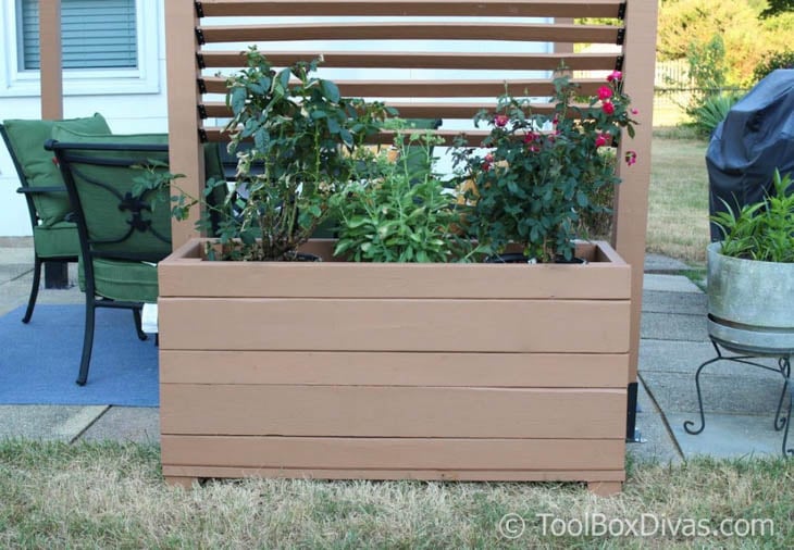 large wood planter box with greenery next to outdoor space
