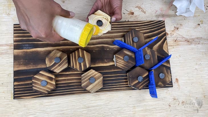 glueing hexagon times on board using wood glue