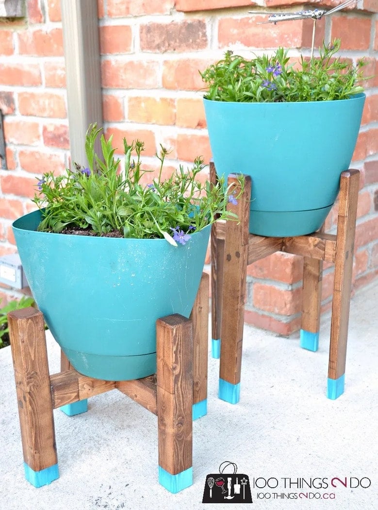 wooden four legged plant stands with teal pots