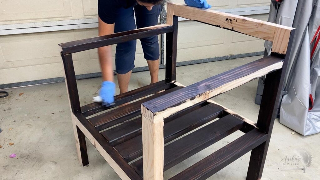 Woman staining completed chair in dark brown