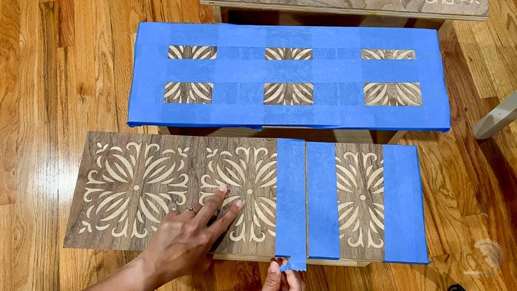 woman applying painters tape to apply veneer to drawer front.