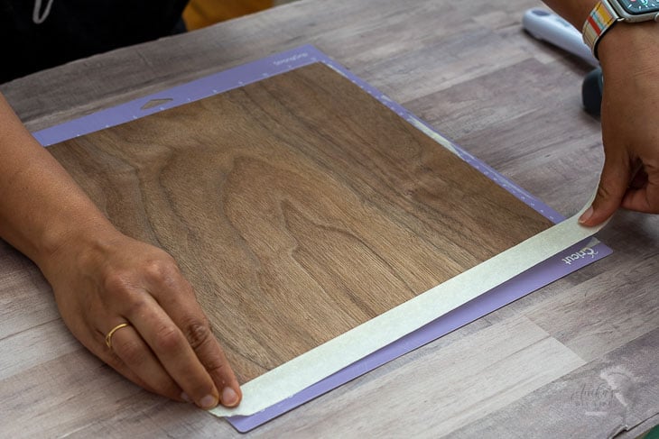 woman loading veneer onto a Cricut mat to make dresser drawer fronts