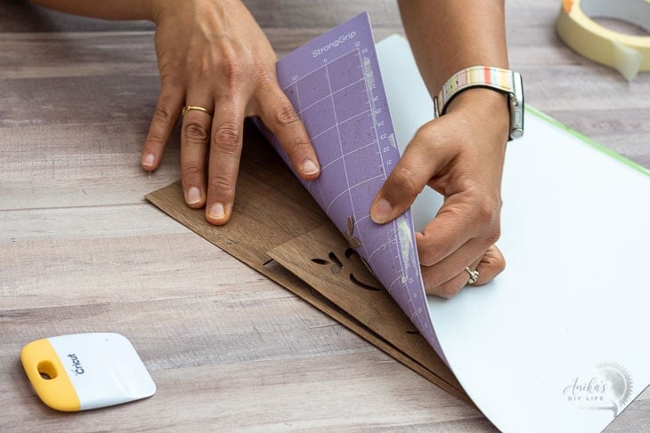 woman unloading the cut veneer from the mat for the DIY dresser drawer front
