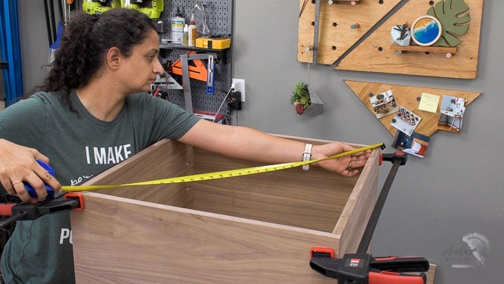 Woman measuring box for square with measuring tape