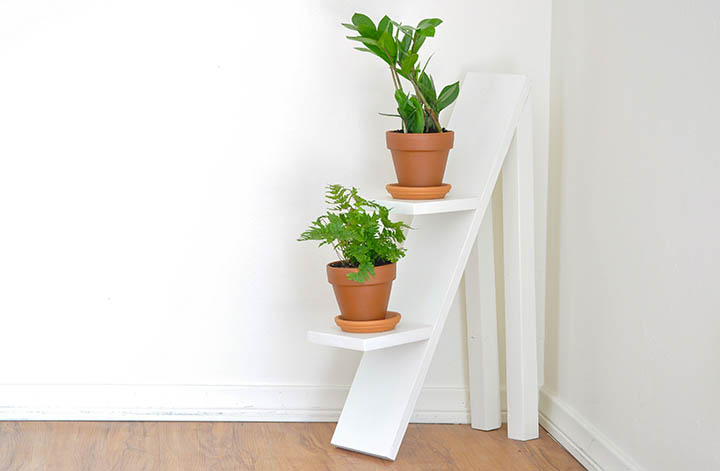 white two tiered plant stand with plants in clay pots