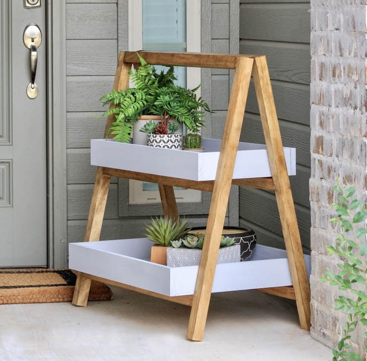 2 tiered A-frame plant stand with plants sitting on front porch