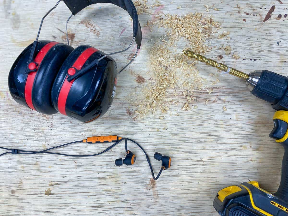hearing protection on workbench with drill and sawdust
