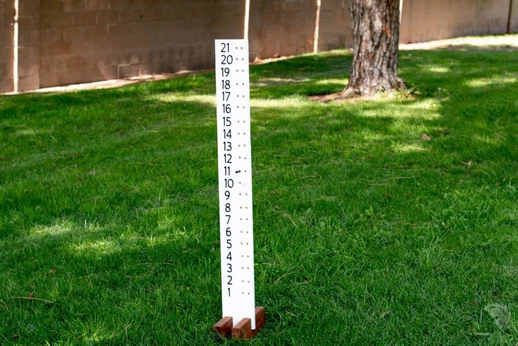 DIY cornhole board score keeper in grass.