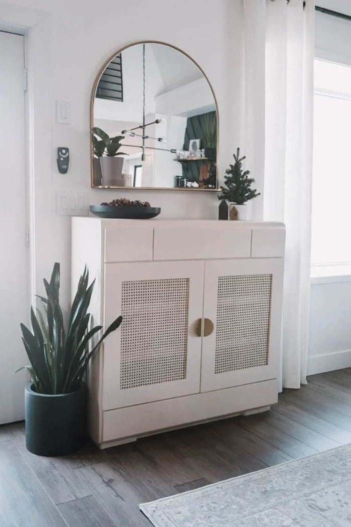 thrifted cabinet painted white with cane webbing door panels