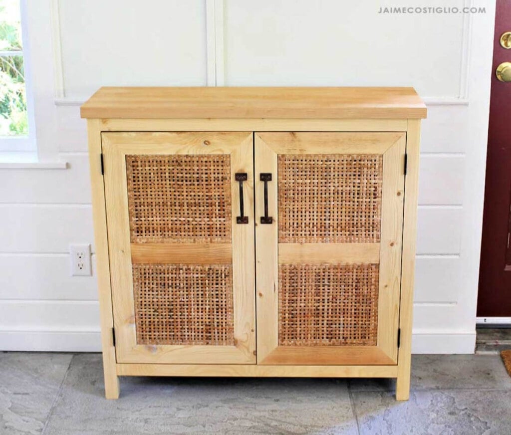 small wood console with two doors with cane webbing inserts
