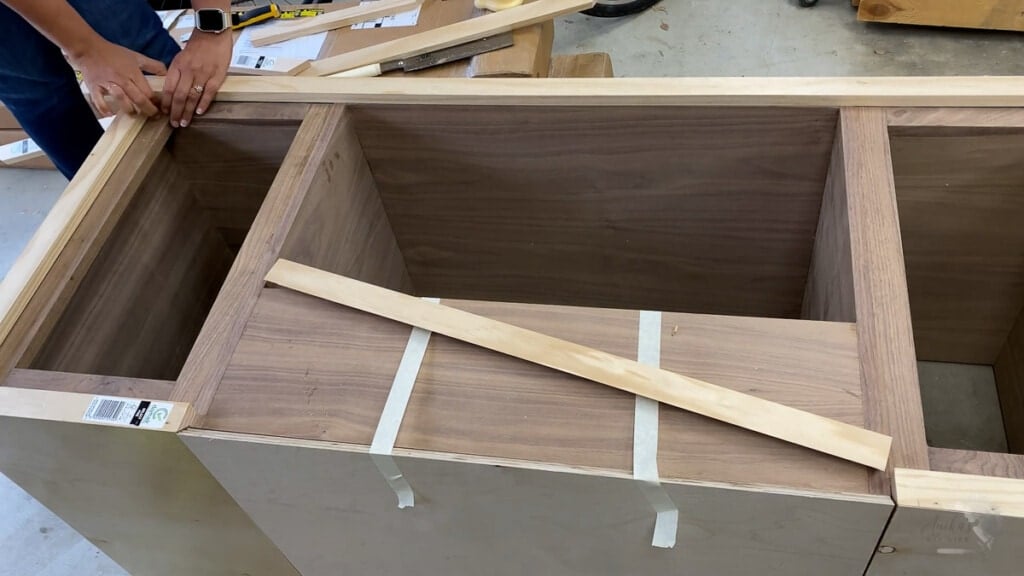 woman attaching trim to the record player cabinet