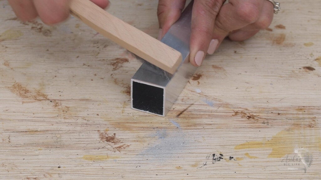 Woman cleaning the edge of the aluminum tube with a wire brush
