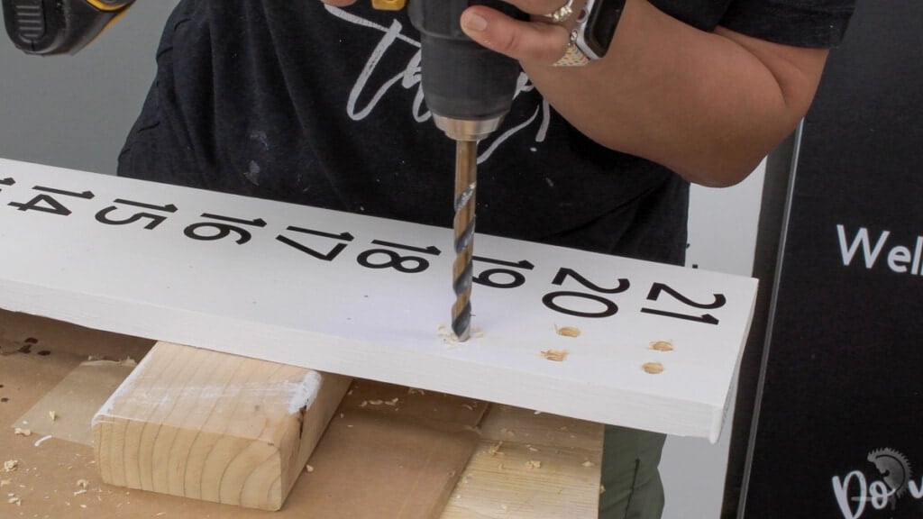 Making holes for dowwls on the cornhole board scorekeeper