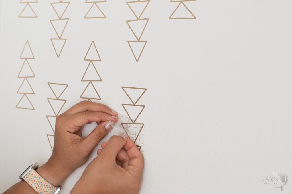 Removing transfer tape from the wall.
