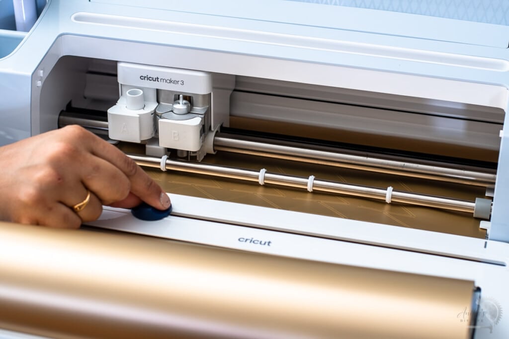 Woman cutting the vinyl with the built-in cutter on the roll holder