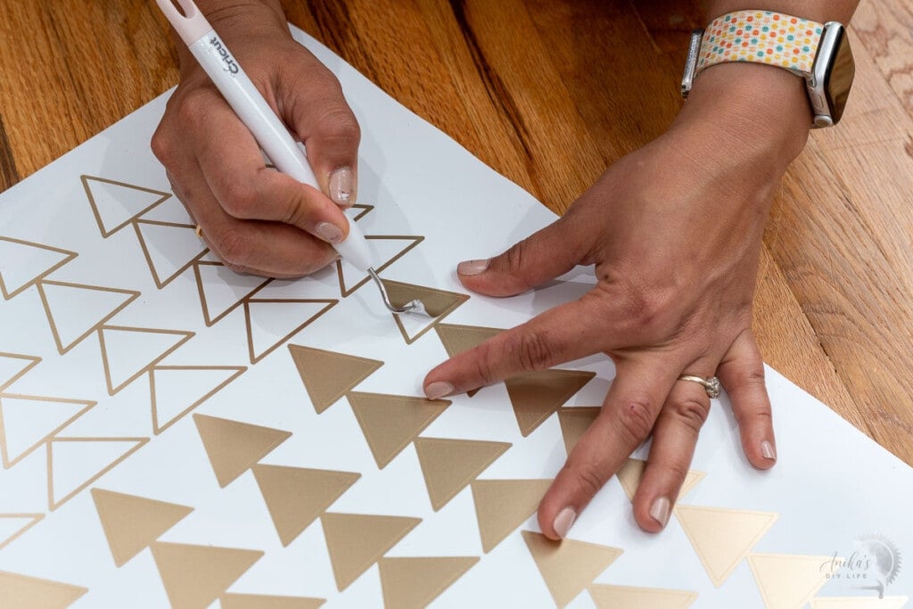 woman weeding the design using a weeding tool