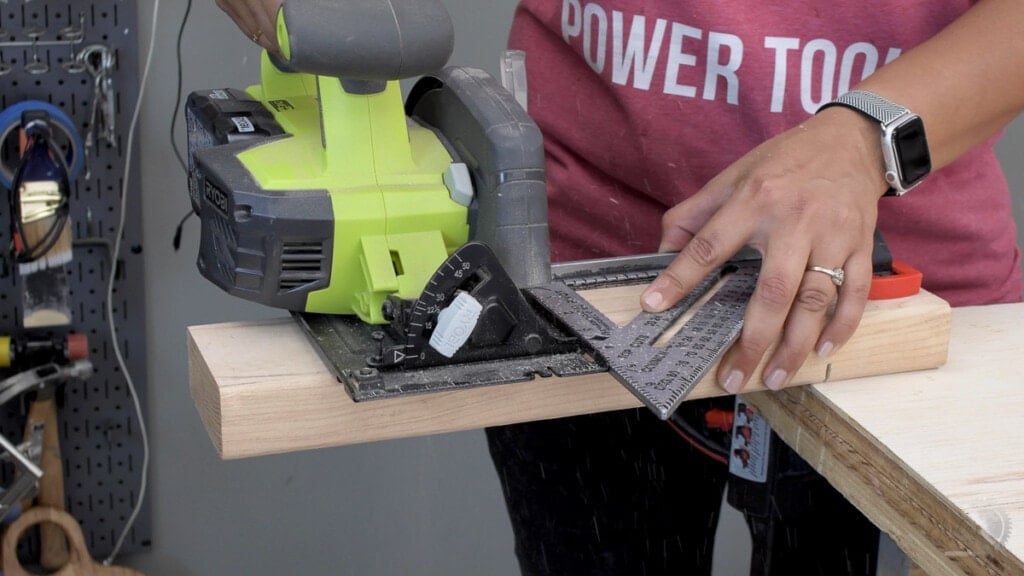 woman cutting a 2x4 with a circular saw