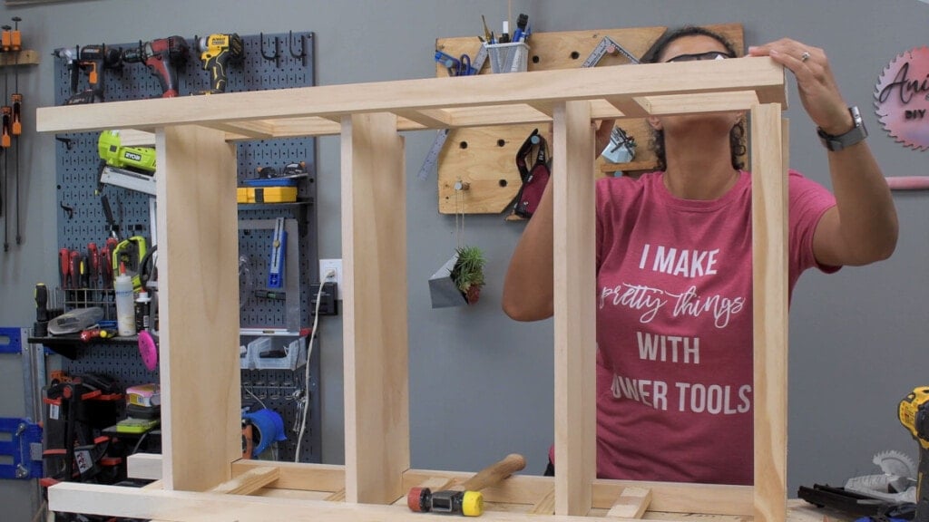 Woman attaching the legs of the DIY bookshelf