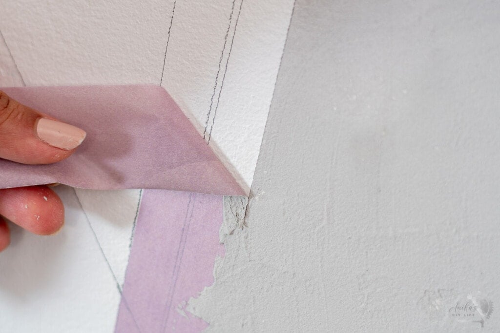 Woman pulling off tape from the DIY concrete wall