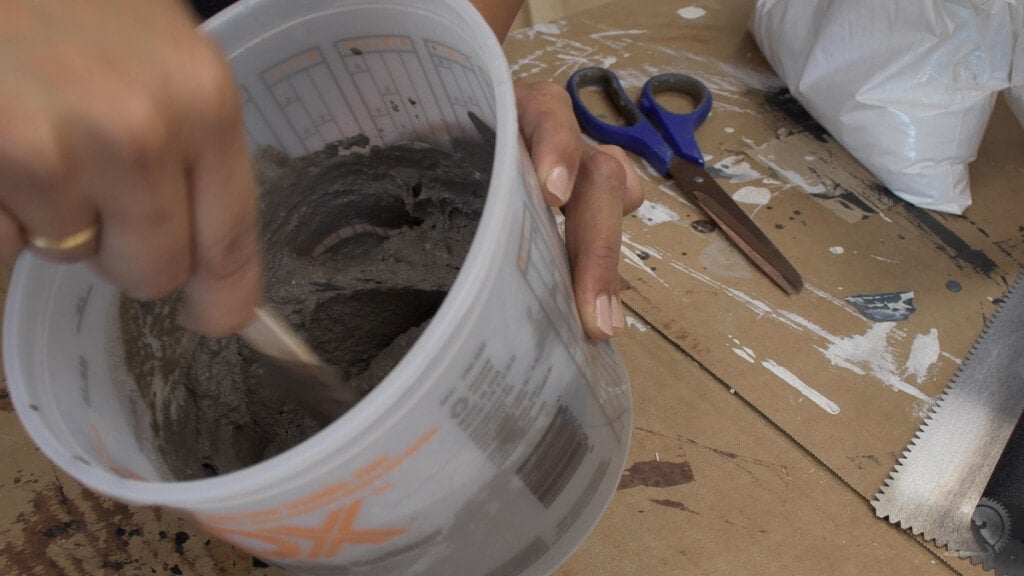 woman mixing concrete for a DIY concrete wall