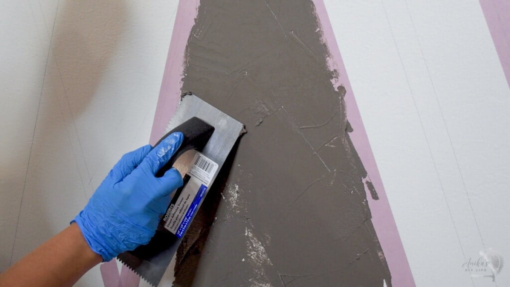 close up of woman applying concrete on the wall.