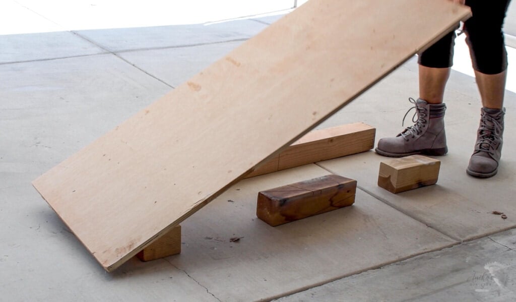 woman setting up the plywood to cut on the floor using structural lumber