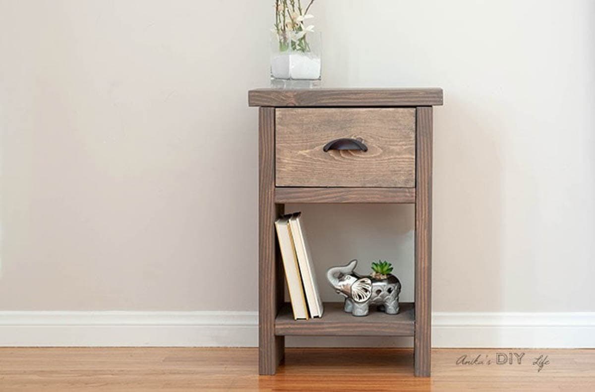 nightstand with one drawer and books and elephant on shelf