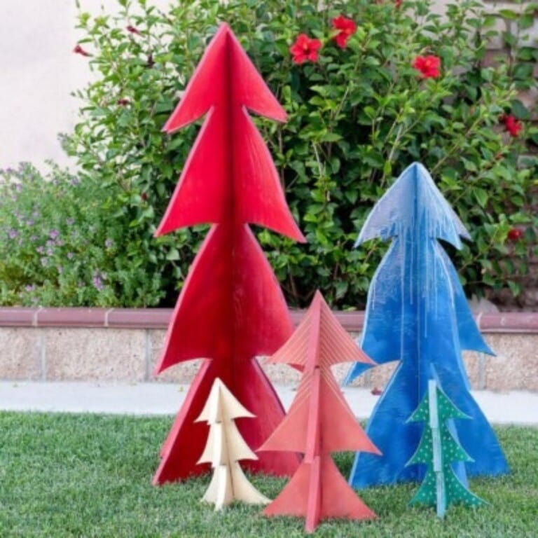 Learn how to make these easy colorful 3-D DIY wooden Christmas Trees using plywood. They are perfect for outdoor yard decor, centerpieces, or even the mantle and can be made using scrap plywood!