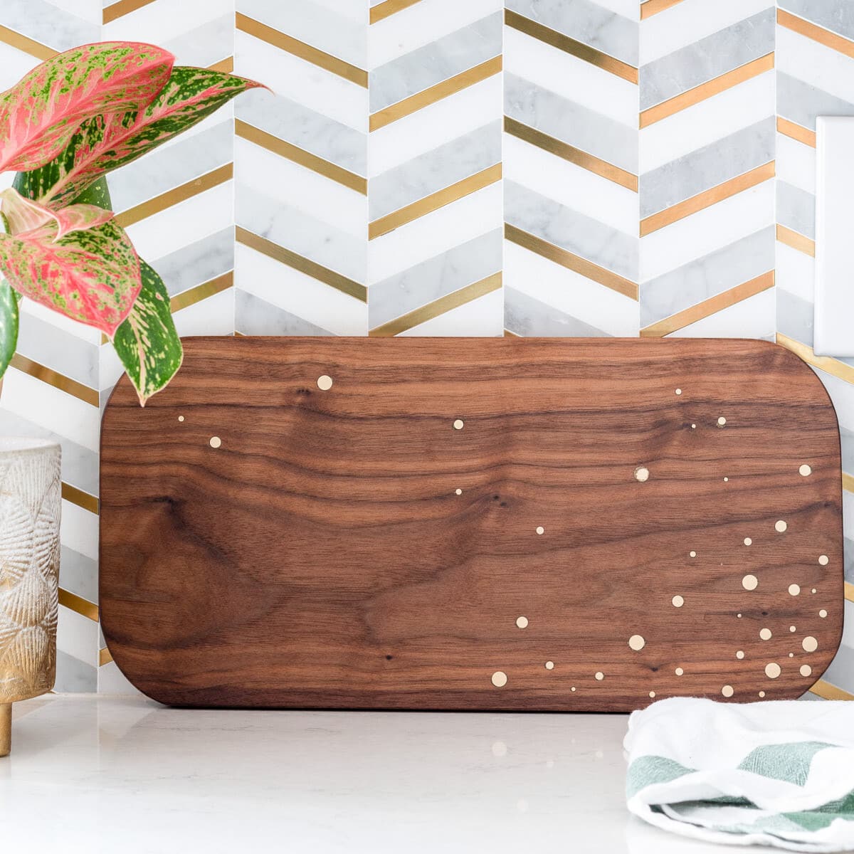 DIY walnut cutting board with brass inlay on countertop