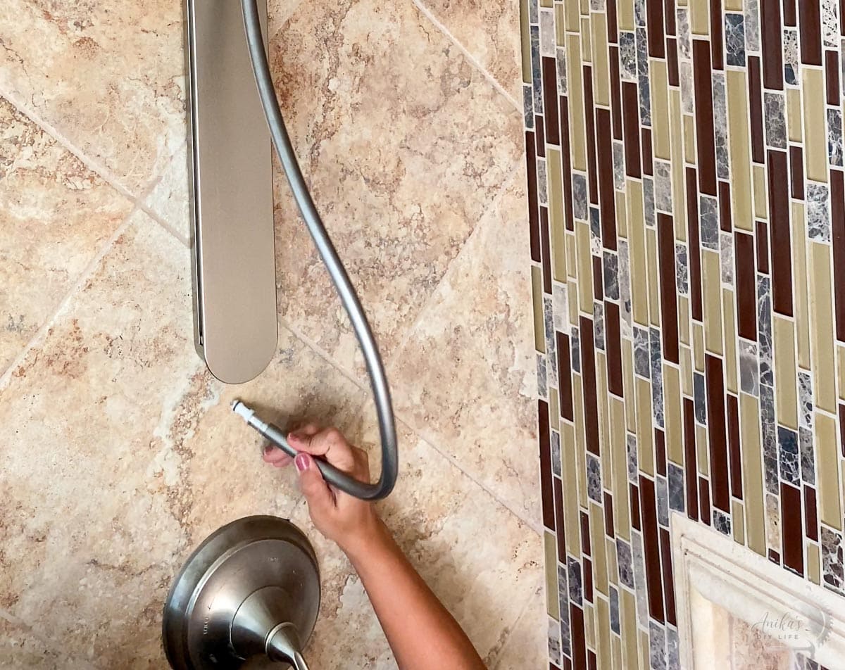woman attaching the hose for the shower