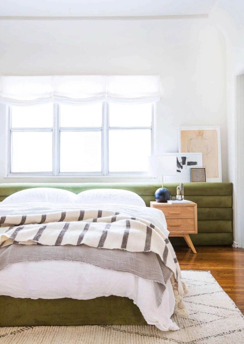 tufted channel headboard in green fabric built across an entire wall