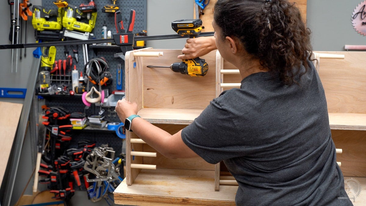 Woman attaching base of bookshelf with pocket hole screws