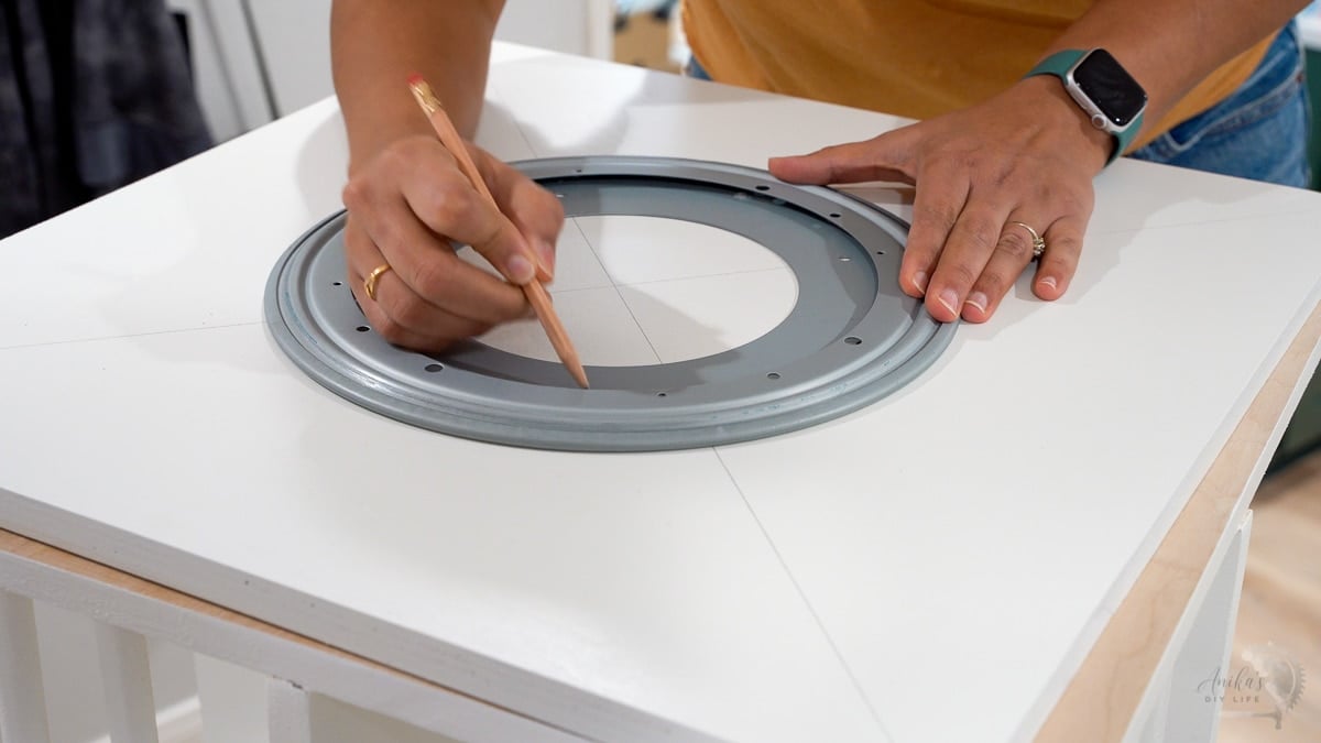 Woman attaching the lazy susan hardware to bookshelf