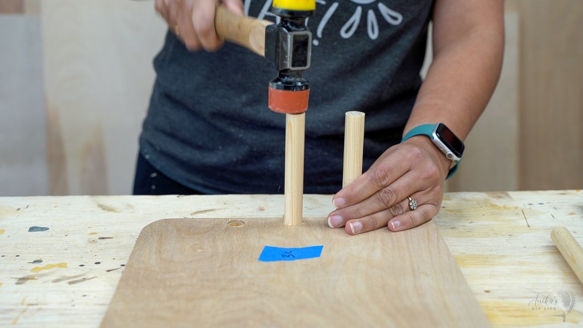 Woman attaching dowels to plywood